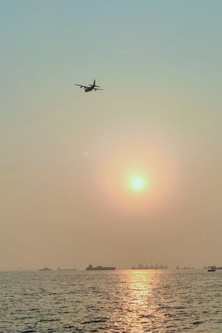 Golden Horizons: A Tranquil Evening Over the Sea 🌅✈️