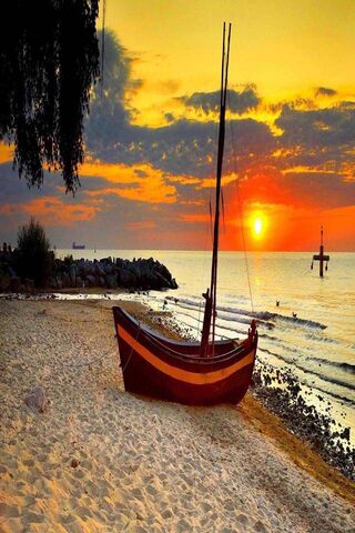 Sunset Serenity: A Boat's Rest on the Shore 🌅⛵