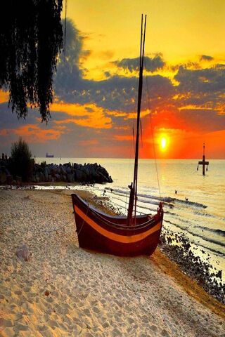 Sunset Serenity: A Boat's Rest on the Shore 🌅⛵